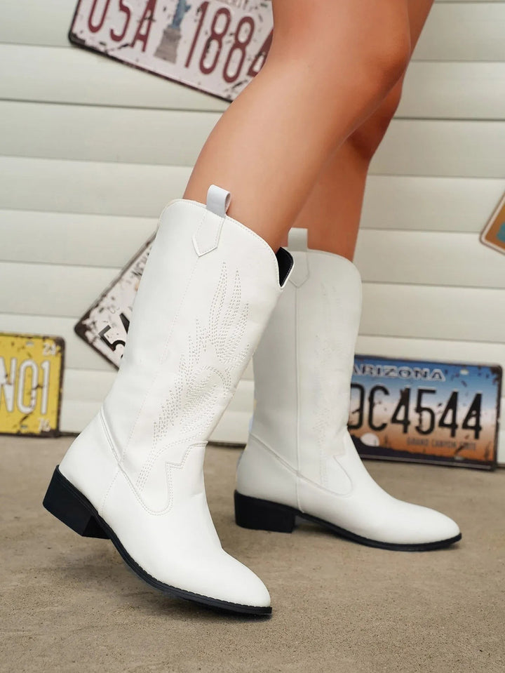 Weiße Cowboystiefel mit Stickerei, seitlich zu Jeans kombiniert