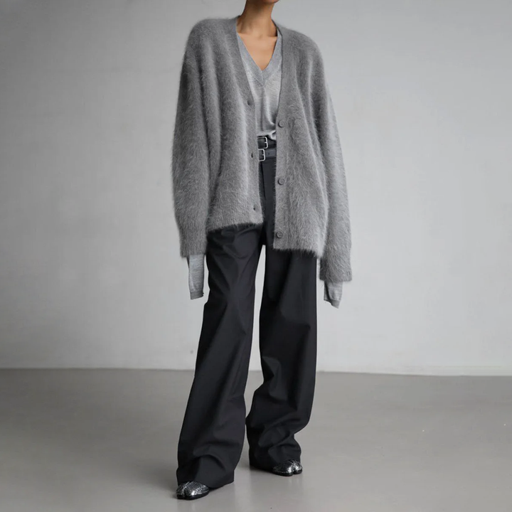 Graue flauschige Cardigan-Strickjacke kombiniert mit weiter schwarzer Stoffhose