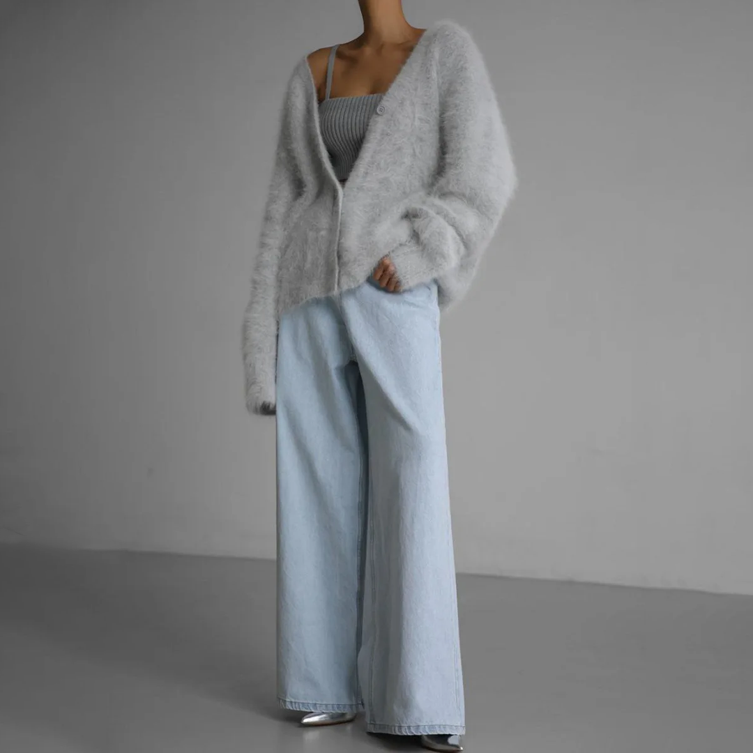 Graue flauschige Strickjacke zu heller Straight-Leg-Jeans getragen