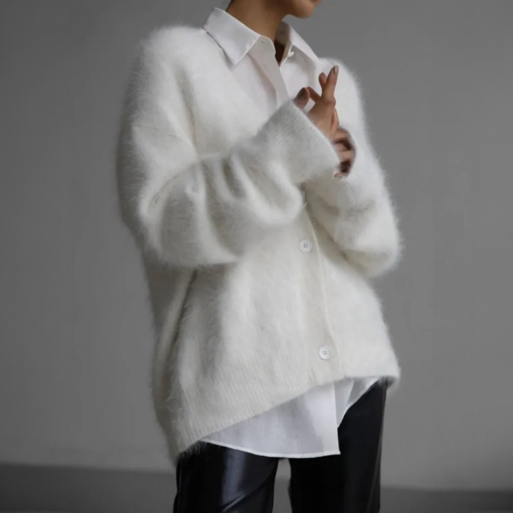 Cremeweiße flauschige Strickjacke über weißem Hemd und schwarzer Lederhose