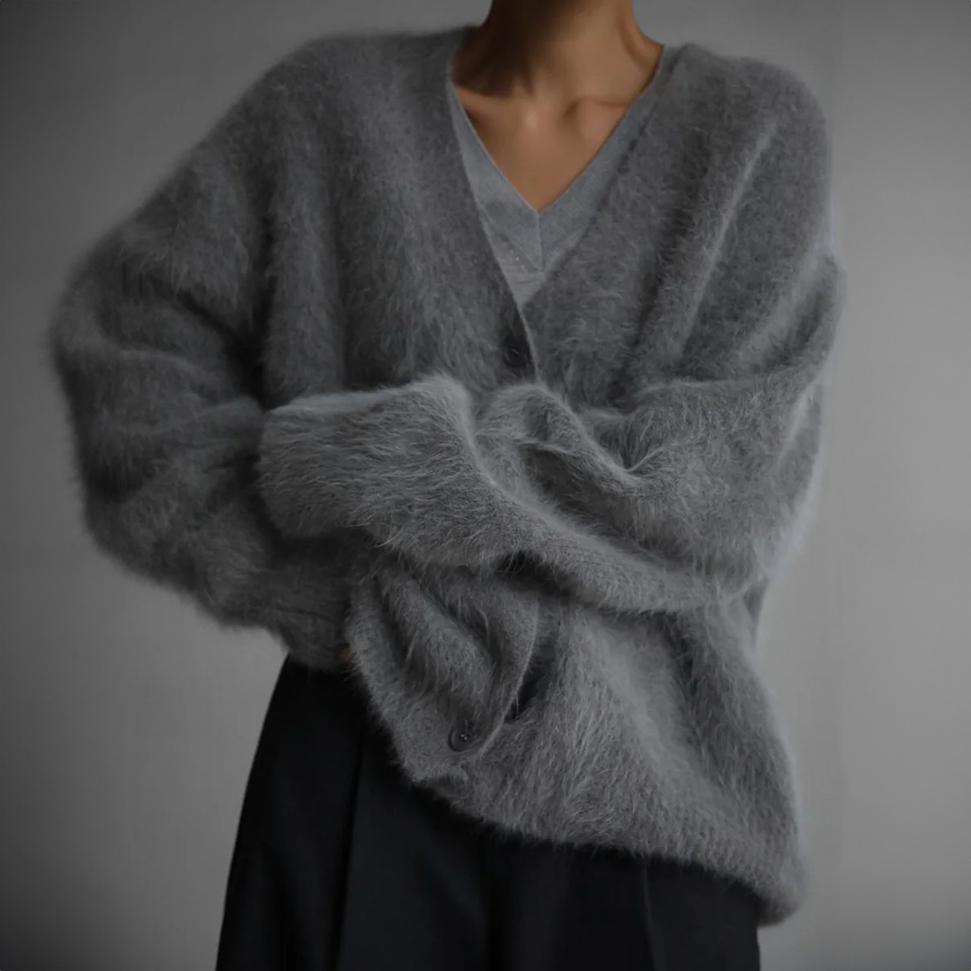 Graue oversized Strickjacke mit Knopfleiste, Ärmel locker verschränkt getragen