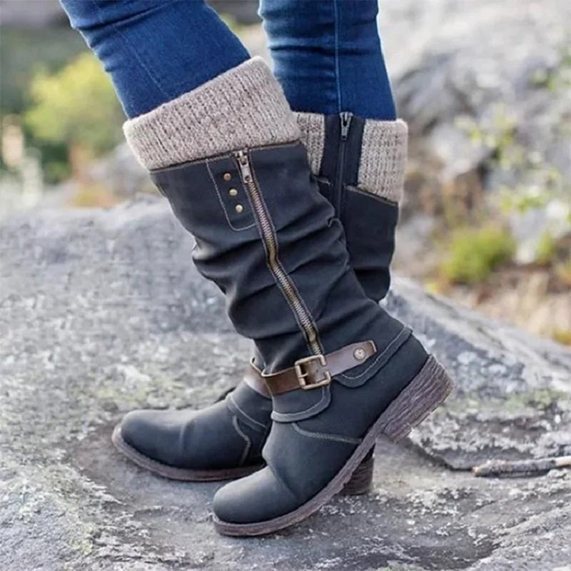 Schwarze Kniehohe Stiefel am Fuß getragen mit Strickbund und Schnalle