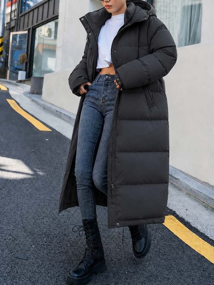 Schwarzer Oversize-Steppmantel mit hohem Kragen, offen getragen zur Jeans