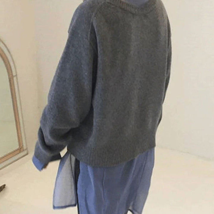 Rückansicht grauer Strickjacke mit Seitenschlitzen über fließendem Kleid