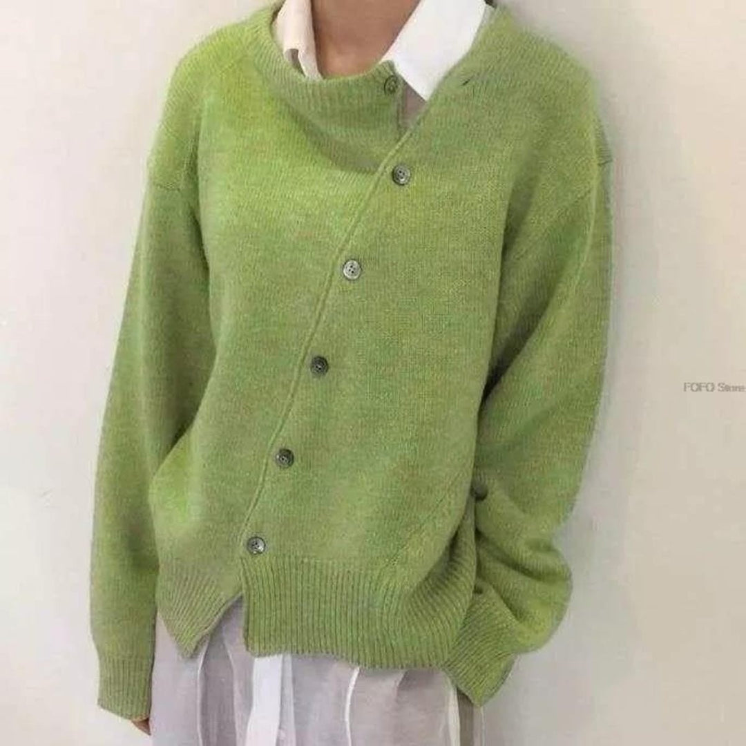Grüne Strickjacke mit asymmetrischem Knopfverschluss über weißem Hemdkragen
