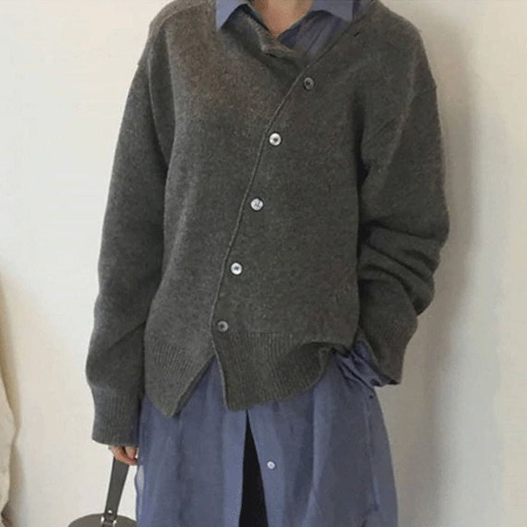 Graue Strickjacke mit versetzter Knopfleiste und sichtbaren Seitenschlitzen