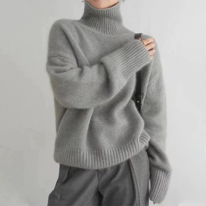 Grauer Strickpullover mit hohem Rollkragen und lockerer Silhouette von vorne