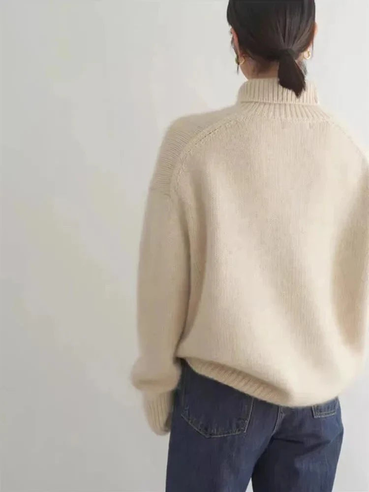 Cremefarbener Rollkragenpullover von hinten mit fallenden Schultern und Raglanärmeln