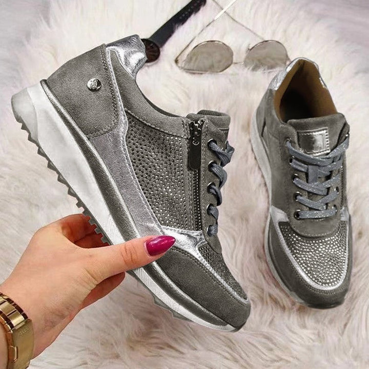 Silberfarbene Sneaker mit Strassbesatz, Reißverschluss und Plateausohle im Detail