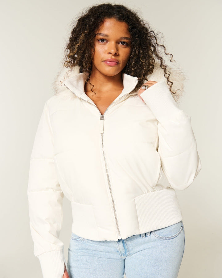 Cremeweiße Steppjacke mit Kunstfellkapuze und Rippbündchen zu heller Jeans
