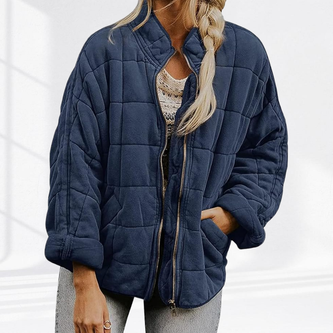 Dunkelblaue Oversize-Steppjacke offen getragen über gestricktem Top