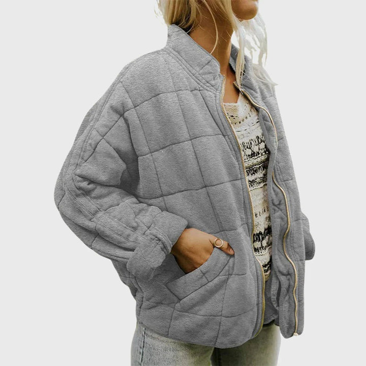 Graue Steppjacke mit Kastensteppung und goldenem Reißverschluss