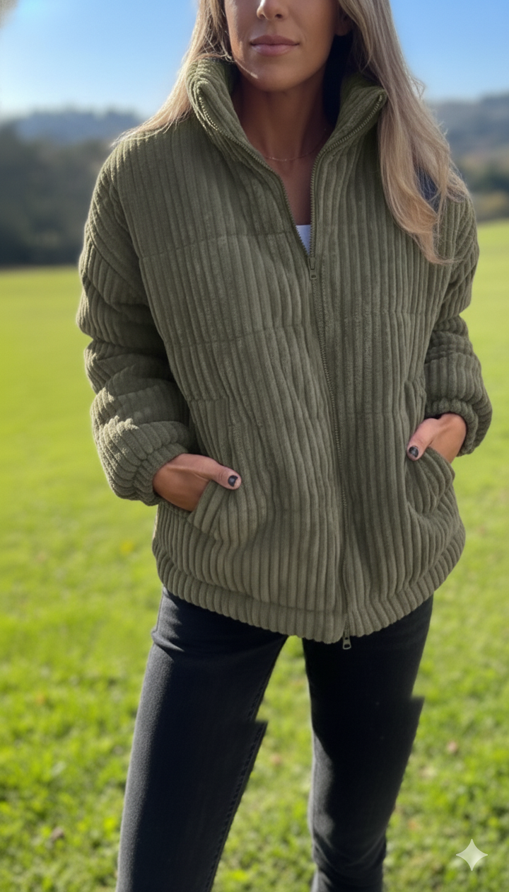 Olivgrüne Cord-Winterjacke mit Stehkragen getragen auf grüner Wiese