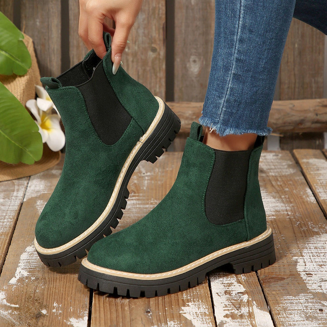 Tannengrüne Chelsea Stiefeletten mit elastischem Einsatz, in der Hand gehalten