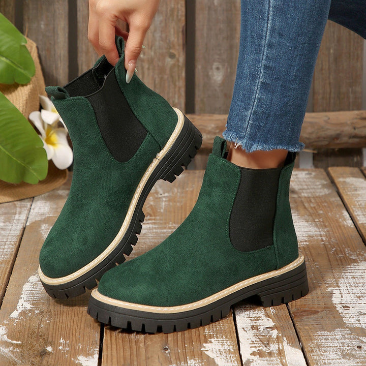 Tannengrüne Chelsea Stiefeletten mit elastischem Einsatz, in der Hand gehalten