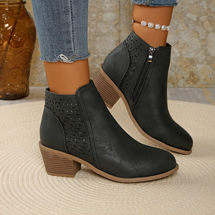Dunkelgraue Stiefelette mit Lochmuster und seitlichem Reißverschluss am Fuß