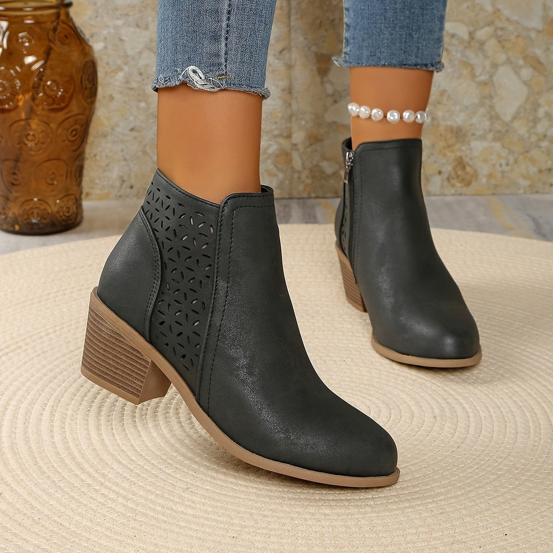 Graue Ankle Boots mit Perforation und stabilem Blockabsatz, schwebend präsentiert