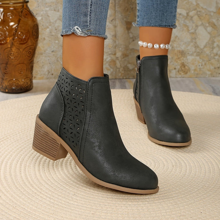Graue Ankle Boots mit Perforation und stabilem Blockabsatz, schwebend präsentiert