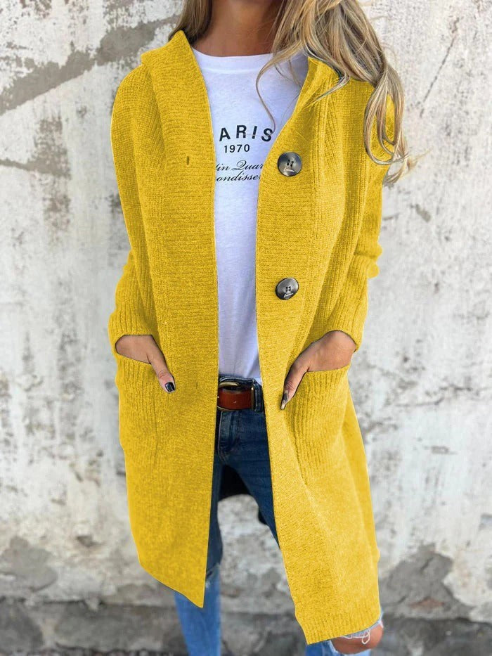 Senfgelbe lange Strickjacke mit Kapuze, offen getragen über weißem Shirt