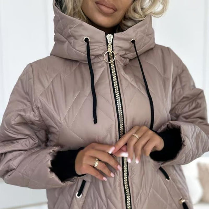 Nahaufnahme des Reißverschlusses und Kapuzenkragens der rosa Steppjacke