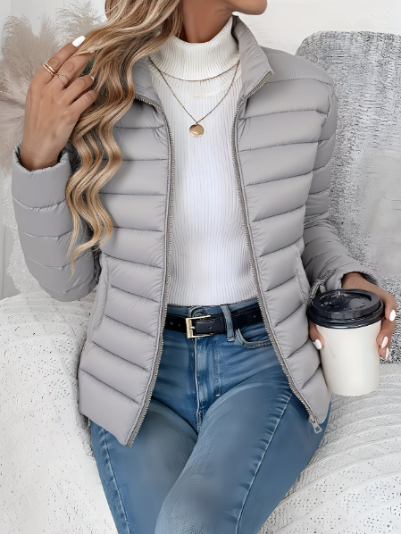 Graue Steppjacke mit Stehkragen, lässig kombiniert mit hellen Jeans