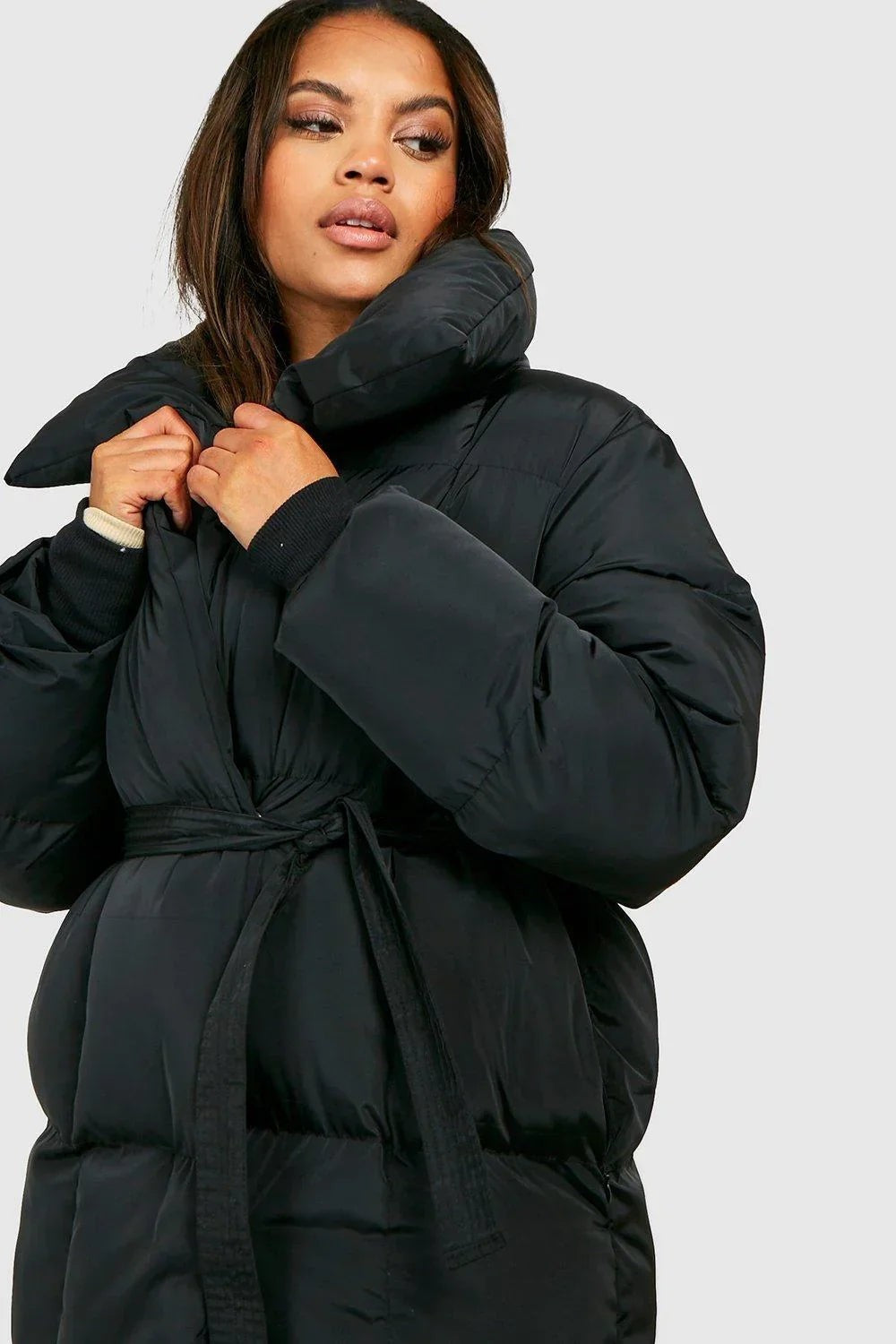Nahaufnahme schwarze wattierte Winterjacke mit übergroßem Stehkragen und Gürtel