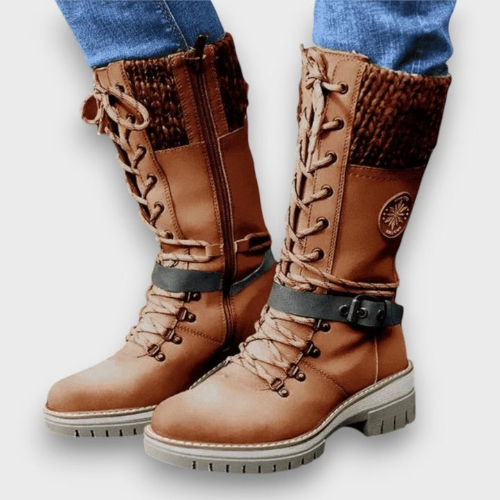 Cognacfarbener Winterstiefel mit Strickmanschette und Schnalle am Bein getragen