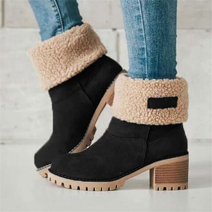 Schwarze Winterstiefeletten mit Kunstfell-Umschlag am Bein getragen mit Jeans