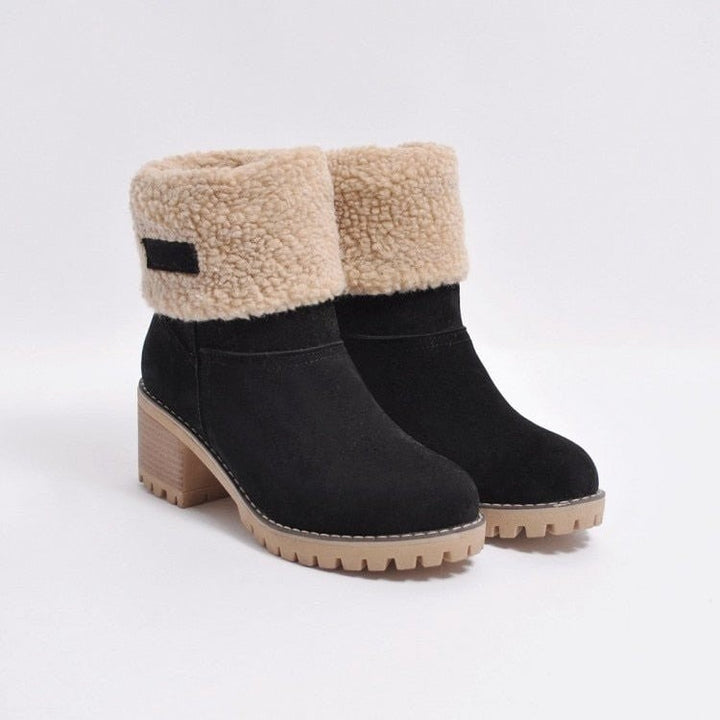 Schwarze Winterstiefeletten mit beigem Fellumschlag und Blockabsatz freigestellt