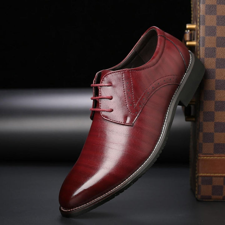 Bordeauxroter Herrenschuh mit Brogue-Lochmuster und schlanker Spitze