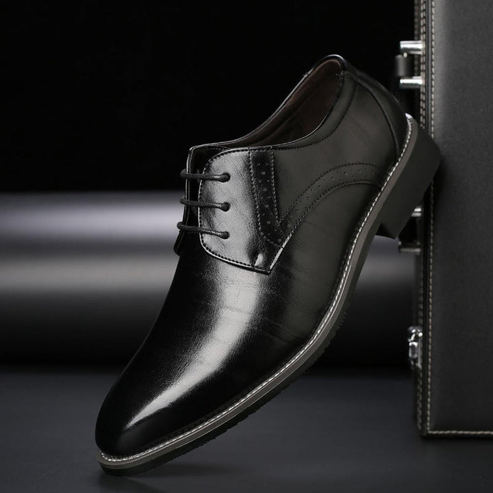 Schwarzer Anzugschuh mit Brogue-Muster und dezenten Kontrastnähten