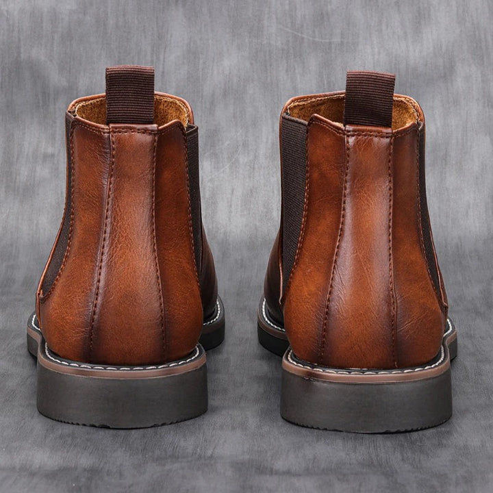 Rückansicht brauner Lederstiefeletten mit Zuglasche und dicker Sohle