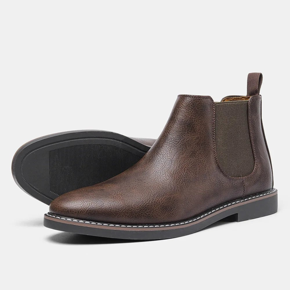 Dunkelbraune Chelsea Stiefeletten mit profilierter Sohle vor hellem Hintergrund