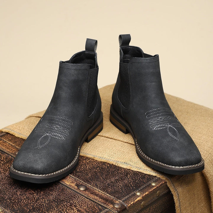 Schwarze Chelsea Boots mit gerippter Sohle und Zugschlaufe im Detail
