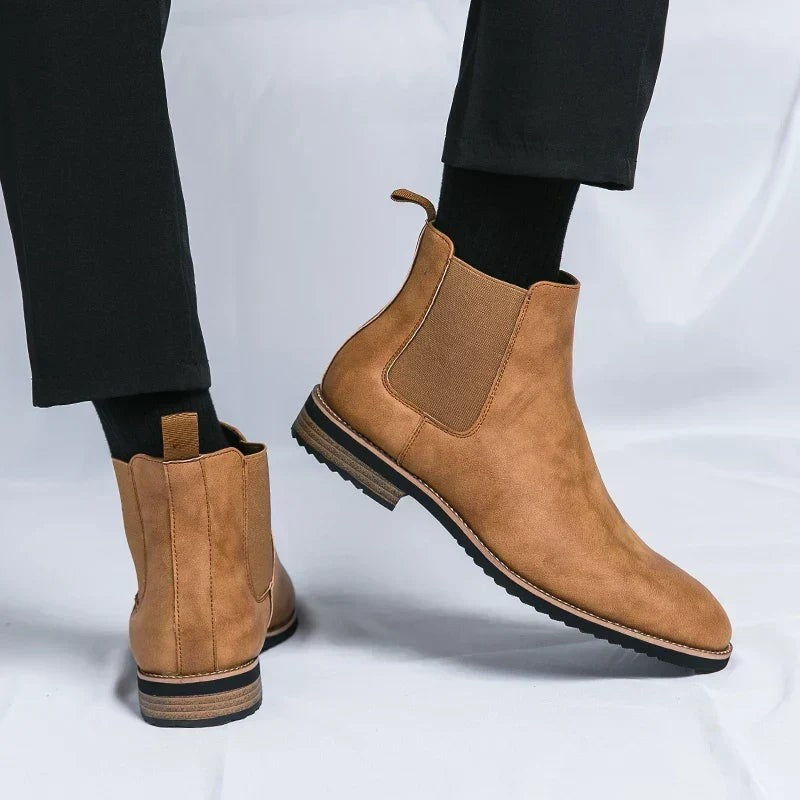 Cognacfarbene Chelsea Boots mit Gummizug-Einsätzen, am Bein getragen
