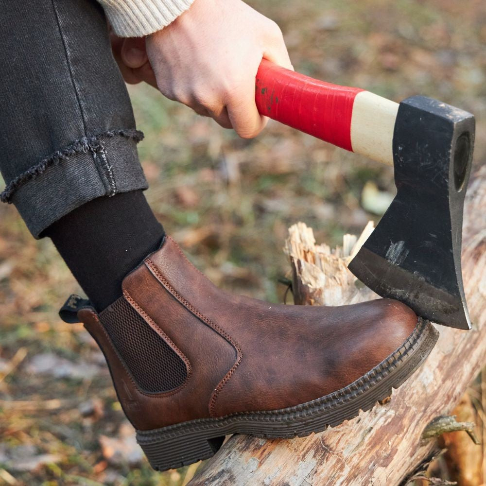 Braune Chelsea-Boots beim Holzhacken im Freien getragen