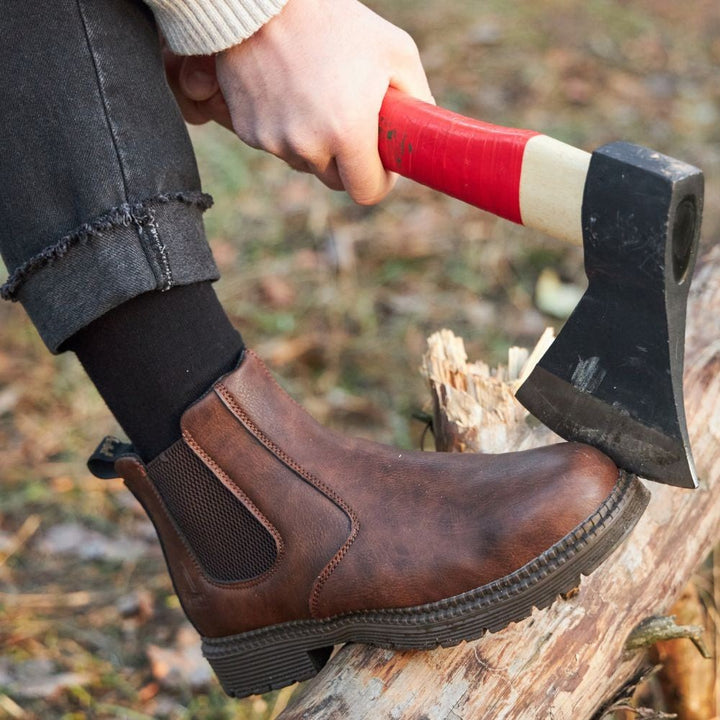 Braune Chelsea-Boots beim Holzhacken im Freien getragen