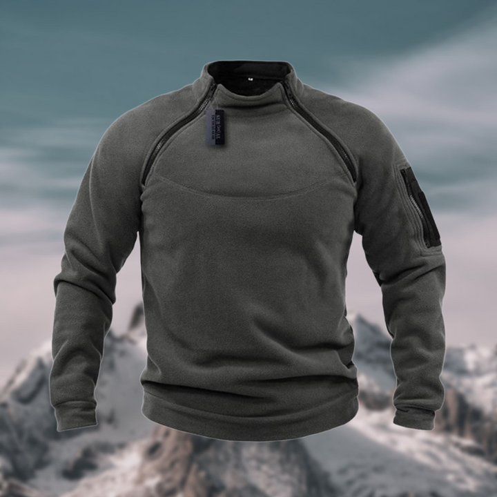 Anthrazitfarbener Fleece-Pullover mit Ärmeltasche vor Bergpanorama