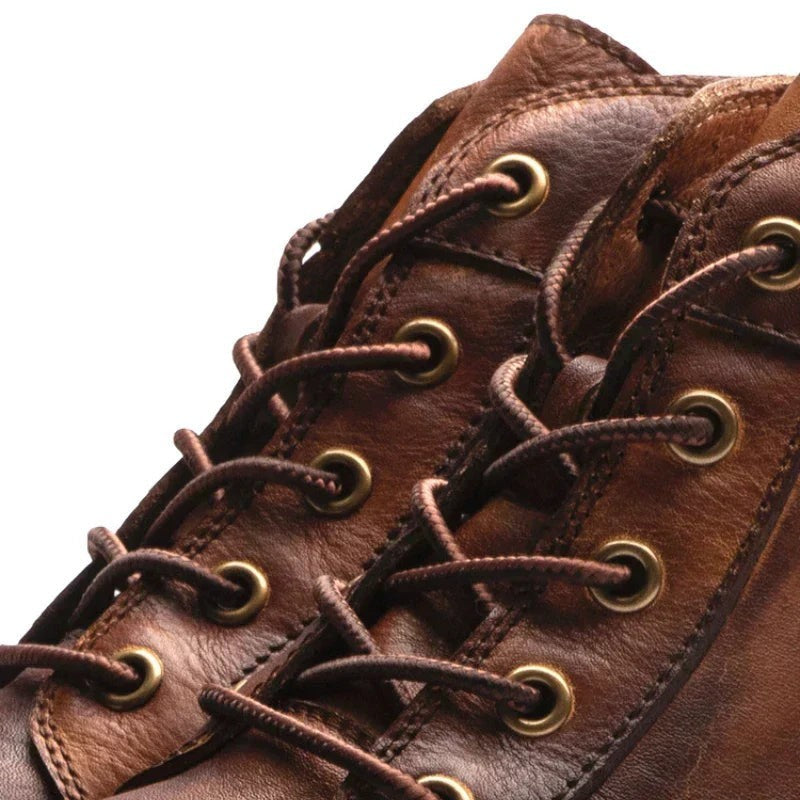 Nahaufnahme Schnürung mit Ösen an braunem Lederstiefel