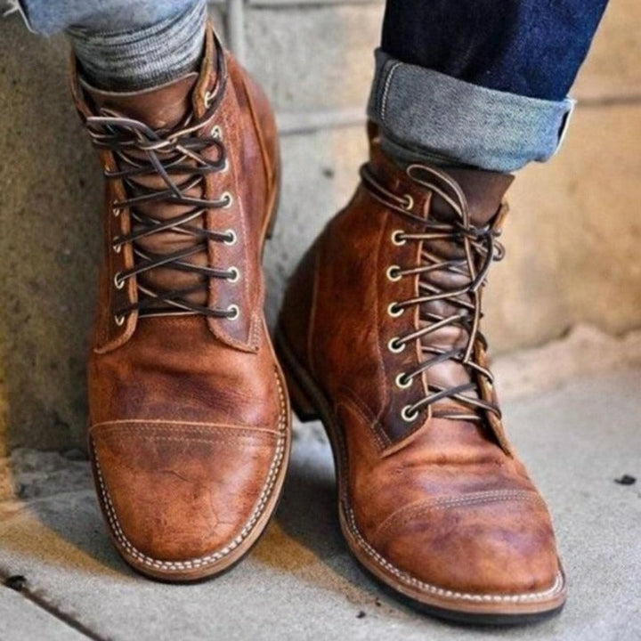 Herren Stiefel aus braunem Leder mit Cap-Toe-Design und Schnürung, kombiniert mit Jeans