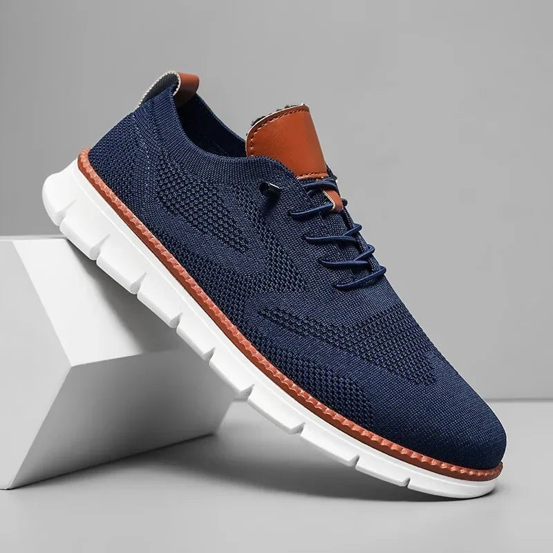 Dunkelblauer Strick-Sneaker mit braunem Ledereinsatz und weißer Sohle