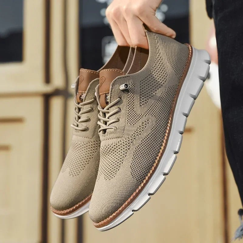 Beige Sneaker Paar mit Strick-Optik in der Hand gehalten