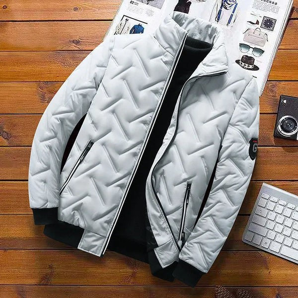 Hellgraue Steppjacke gefaltet auf Holztisch mit Accessoires