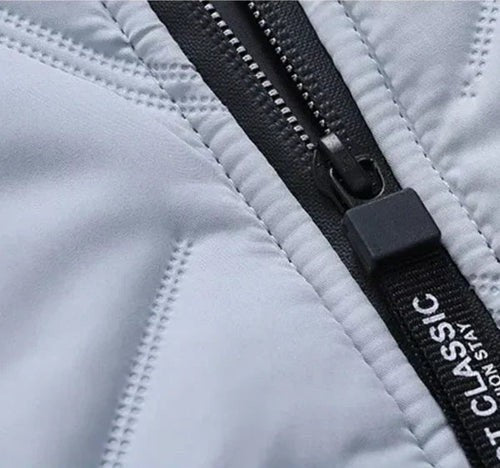 Nahaufnahme des Reißverschlusses mit Classic-Schriftzug an weißer Steppjacke