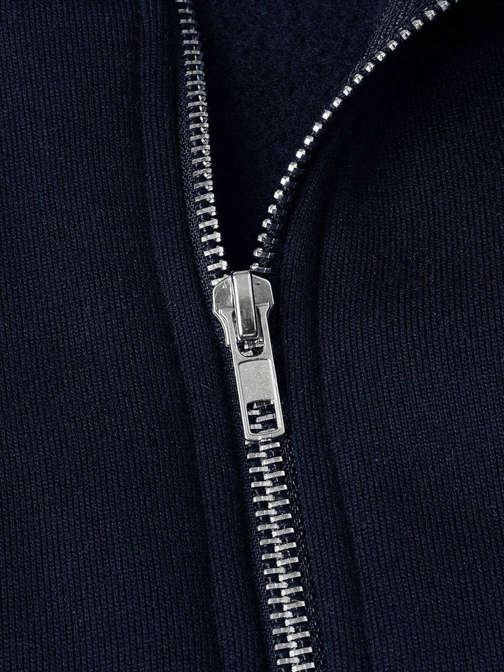 Nahaufnahme des silbernen Reißverschlusses am marineblauen Fleece-Pullover