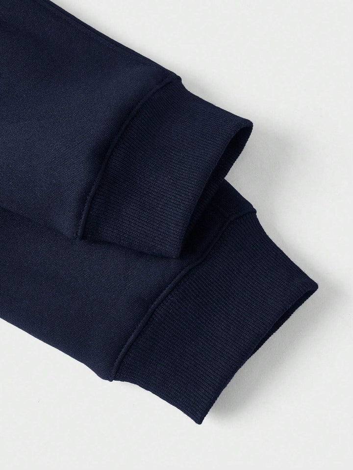 Detailansicht der gerippten Bündchen am marineblauen Herrenpullover