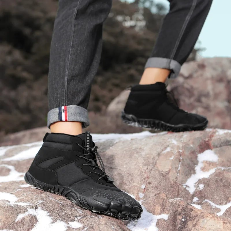 Barfuß Winterstiefel schwarz mit gefütterter Schnürung auf schneebedecktem Felsen