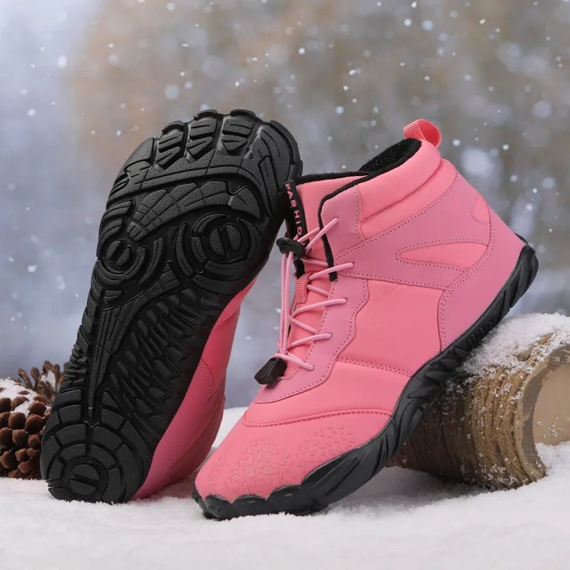 Pinke Barfuß Winterstiefel mit rutschfester Sohle vor winterlichem Hintergrund