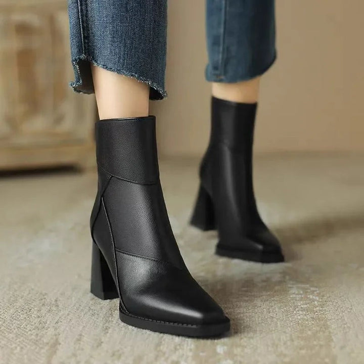 Schwarze Ankle Boots mit Blockabsatz, im Stehen von vorne getragen